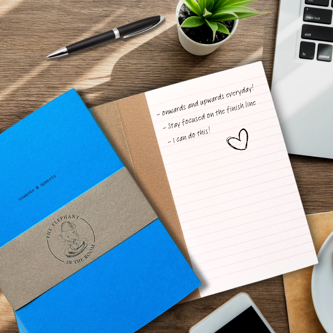 Handmade Notebook in blue with an open page of the book showing lined pages with motivational writing.