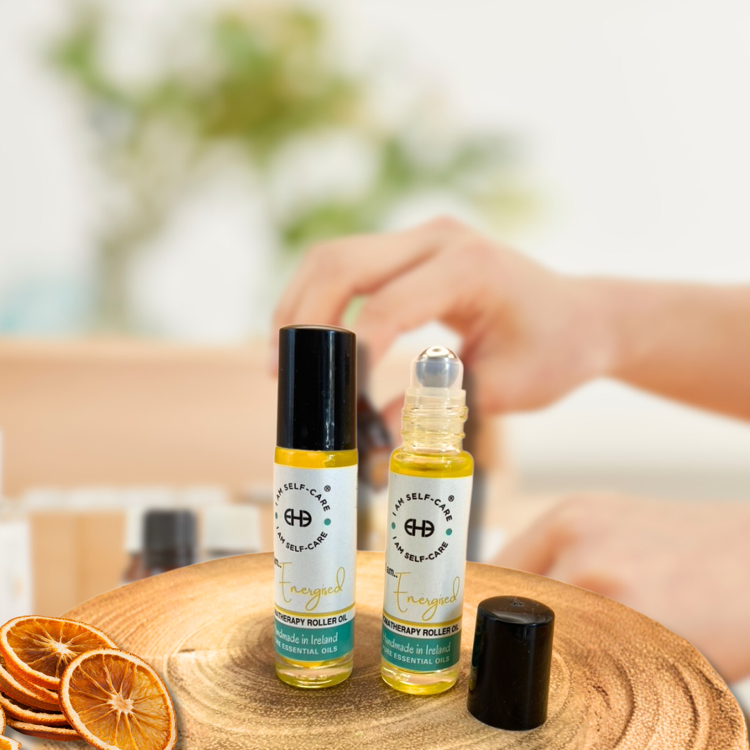 Two roller ball bottle with essential oil for fatigue bottles on a wooden surface with dried oranges.