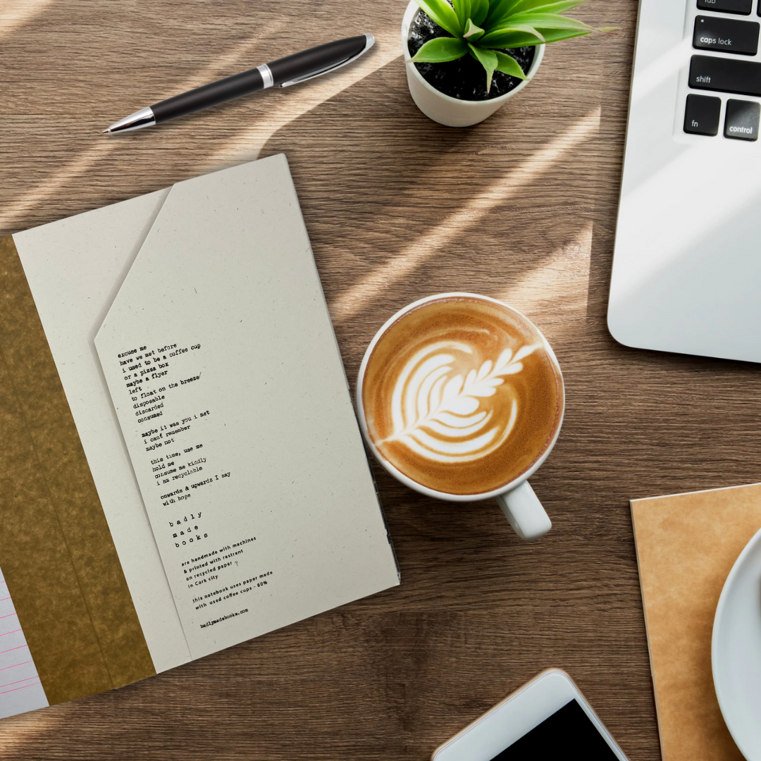 Inside flap of notebook on a desk with a coffee cup