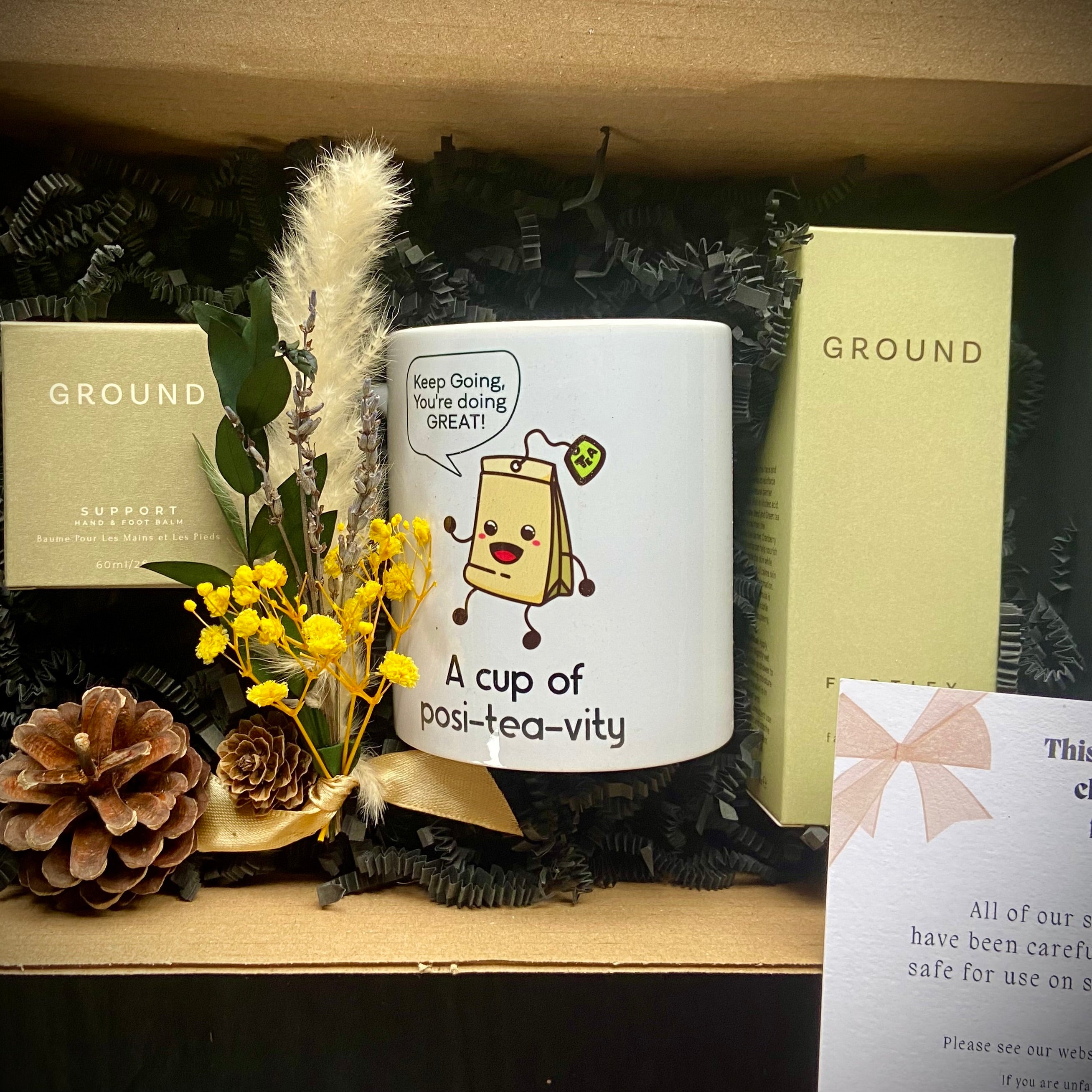 Care package with Ground Wellbeing skincare products and a mug with a positive message