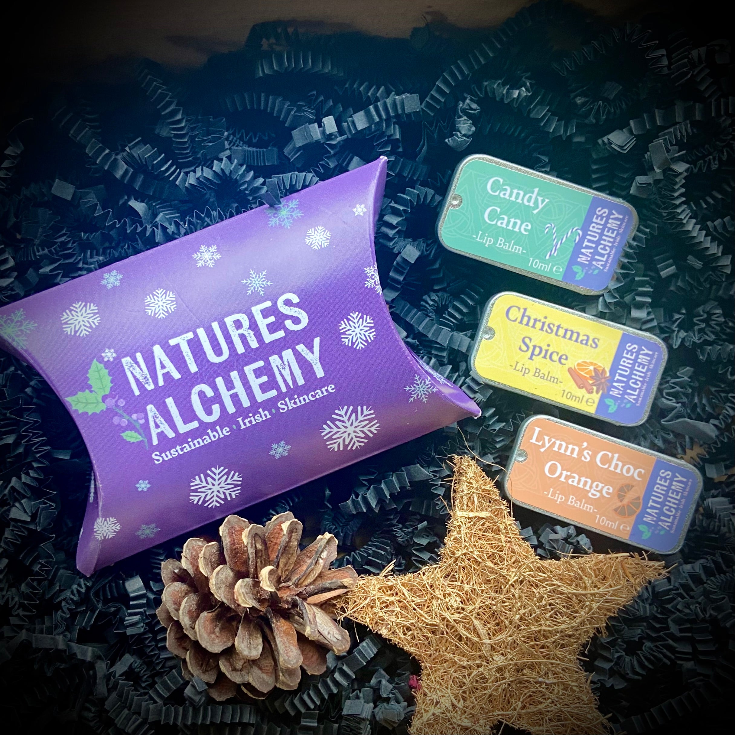 three lip balms in a care package with festive decorations