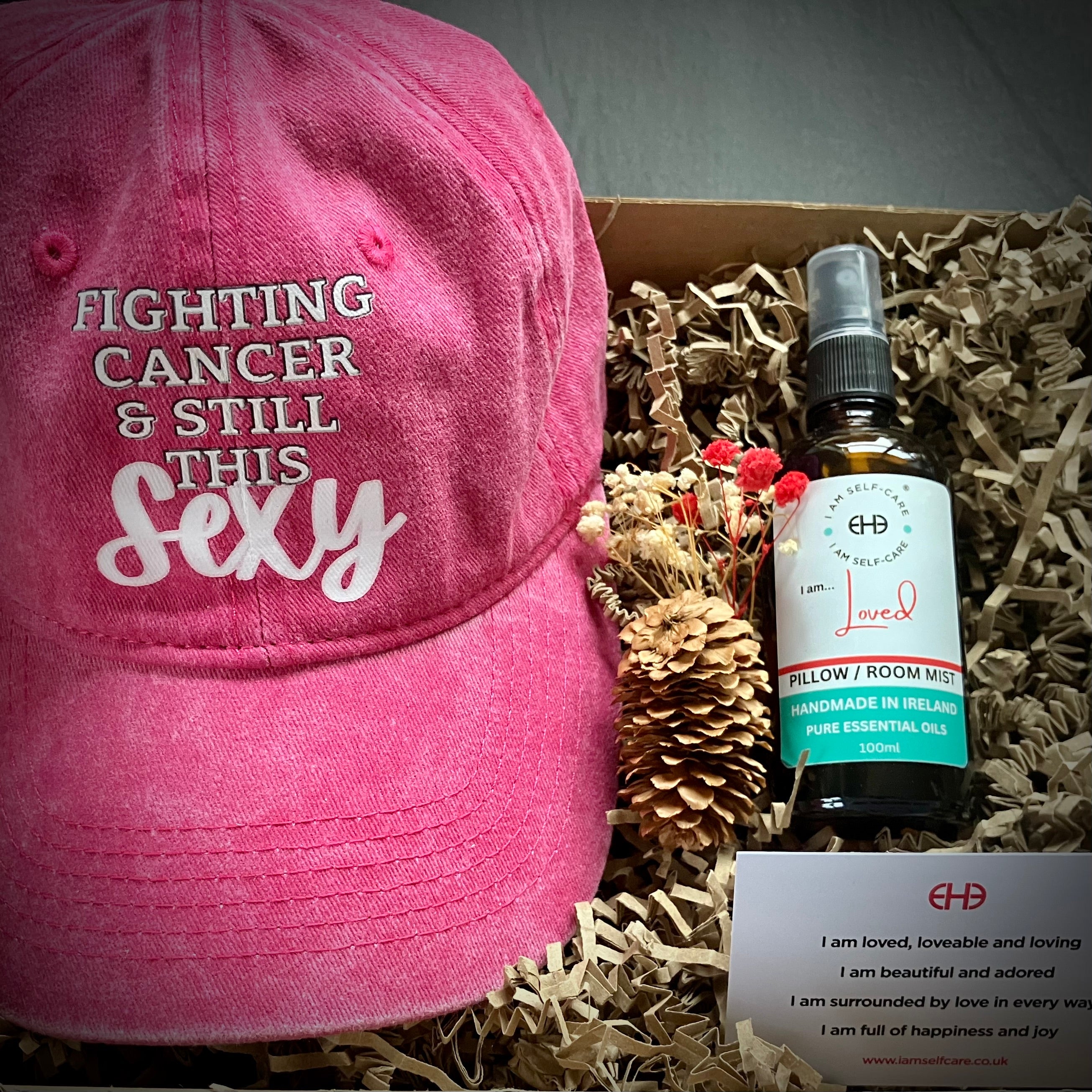 Gift box for cancer patient with pink baseball hat and aromatherapy pillow mist