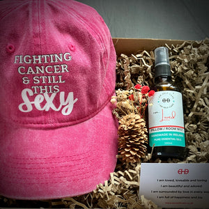 Gift box for cancer patient with pink baseball hat and aromatherapy pillow mist