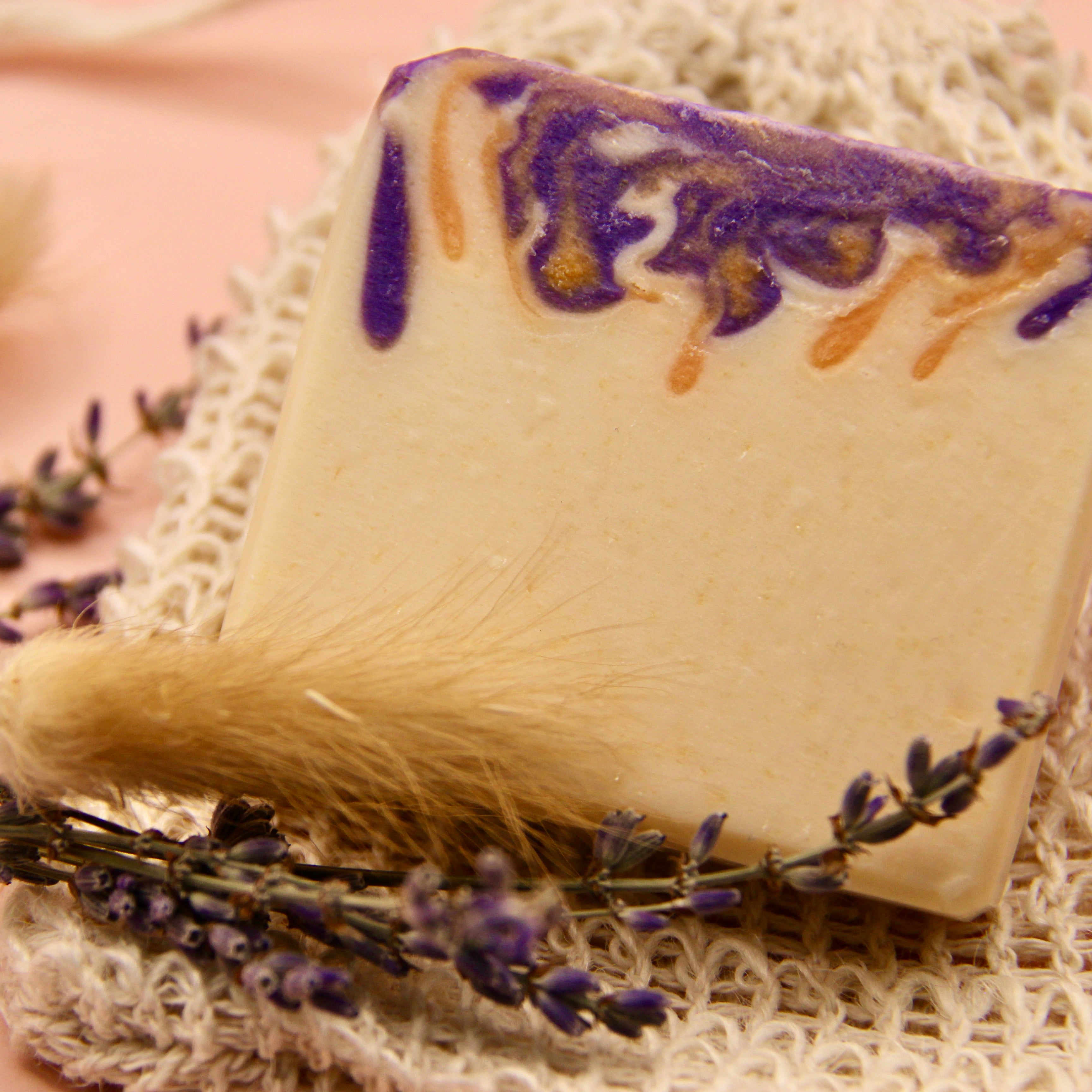 Close up of goats milk lavender soap for sensitive skin with sprigs of lavender