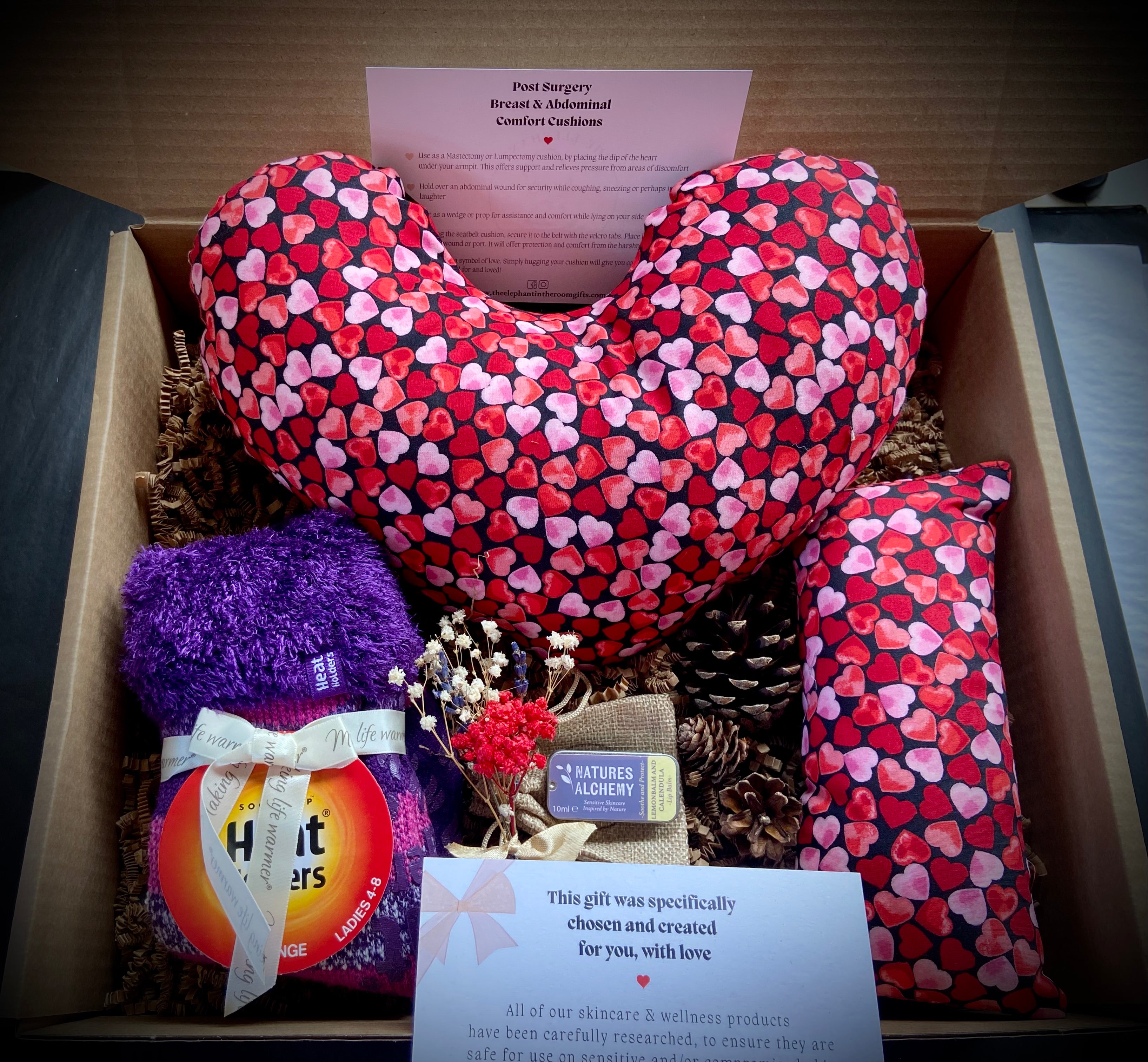 Post surgery care package with socks, lip balm, post surgery cushion and post surgery seat belt cushion packed in a gift box