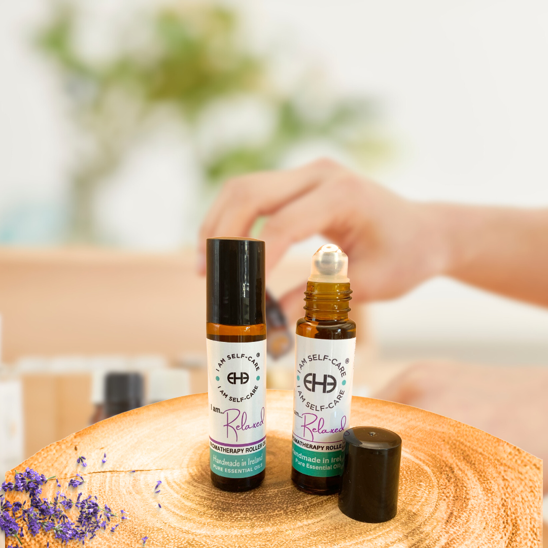 Two lavender oil rollerball  bottles lon a wooden surface with blurred background